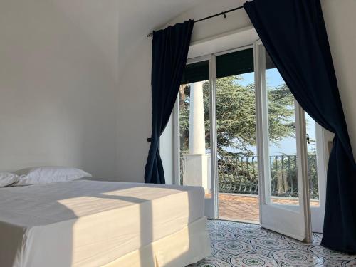 1 dormitorio con 1 cama y puerta corredera de cristal en Casa Bella Capri, en Capri
