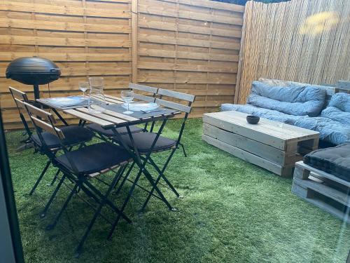 une table, des chaises, des verres à vin et un canapé dans l'établissement Beau studio proche mer, gare et commerces, à Antibes