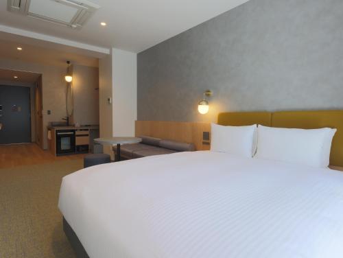 a large white bed in a hotel room at HOTEL Tomiya with M's in Kyoto