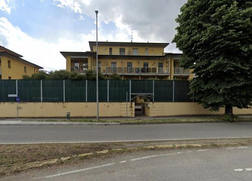 een gebouw met een hek voor een straat bij Il binario blu - 4 posti letto in Melegnano