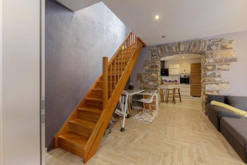 a staircase in a living room with a stone wall at Istrian House La Bora in Koper