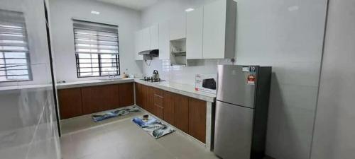 cocina con suelo y nevera. en D'Aster Sara's Homestay Seremban NS, en Seremban