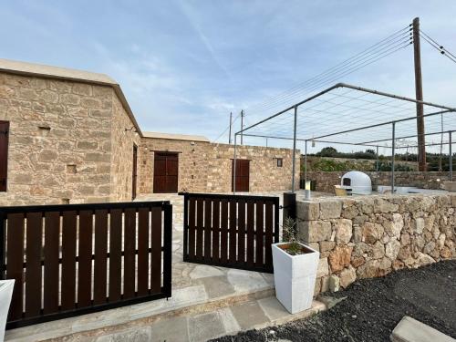 a brick building with a gate and a stone wall at The stone nest in Paphos