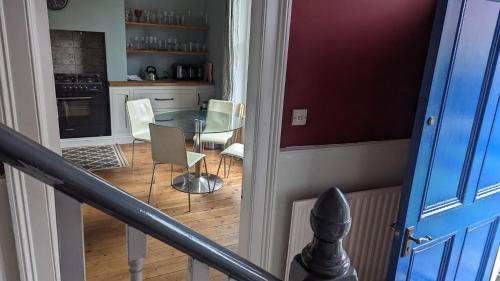 a kitchen with a glass table and chairs in a room at Spacious home, by Headingley Stadium, LGI, Leeds Arena, and the University of Leeds in Headingley