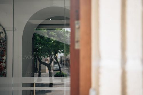 una finestra di un edificio con un cartello sopra di Hotel Boutique Palacio Corredera a Jerez de la Frontera