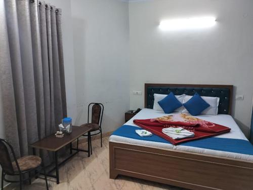 a bedroom with a bed with a table and chairs at HOTEL HOLIDAY INN PARADISE in Chandīgarh