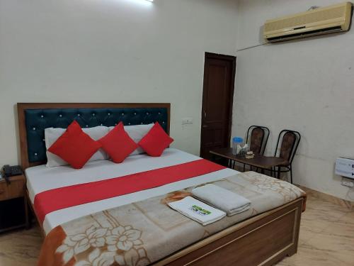 um quarto com uma cama grande e almofadas vermelhas em HOTEL HOLIDAY INN PARADISE em Chandīgarh