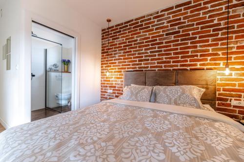 a bedroom with a brick wall and a bed at House "Mediterrian spirit" with jacuzzi in Zadar in Zadar