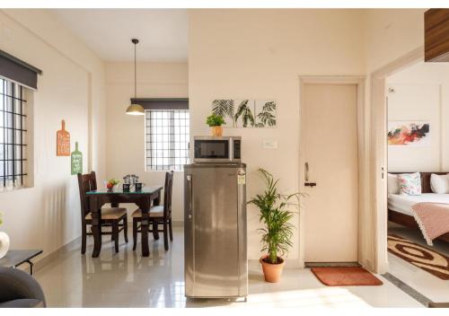 a kitchen and living room with a refrigerator and a table at BluO Park View 1BHK HSR Layout - Terrace Garden in Bengaluru