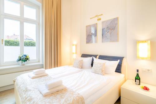 una camera da letto con un grande letto bianco e una finestra di Villa Gruner App 1a a Zinnowitz