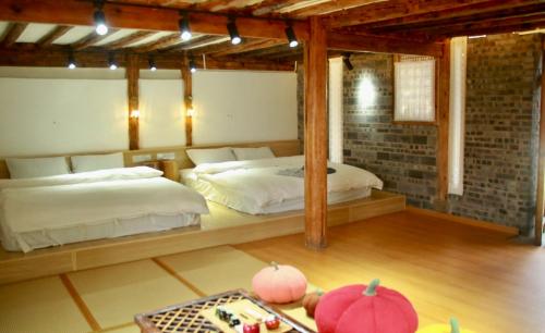 a bedroom with two beds and a table with a tray at Playing Again Hostel in Lijiang