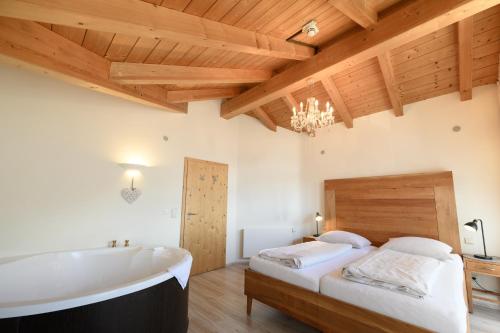 a bedroom with a bath tub and a bed at Biohotel Garmischer Hof in Garmisch-Partenkirchen