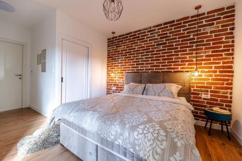 a bedroom with a brick wall and a bed at House "Mediterrian spirit" with jacuzzi in Zadar in Zadar
