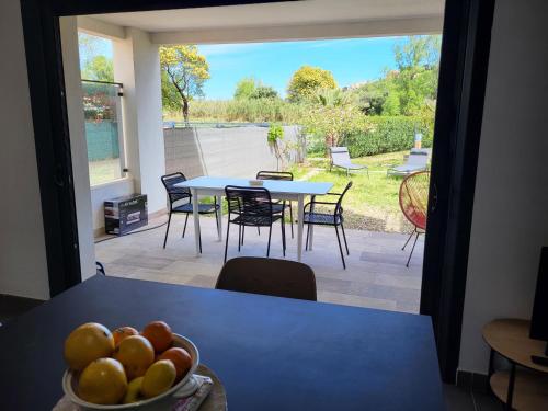 - un bol de fruits sur une table avec une terrasse dans l'établissement Mare e vista Appartement Lumineux avec terrasse et jardin, à Saint-Florent