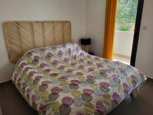 - un lit dans une chambre avec couverture dans l'établissement Mare e vista Appartement Lumineux avec terrasse et jardin, à Saint-Florent