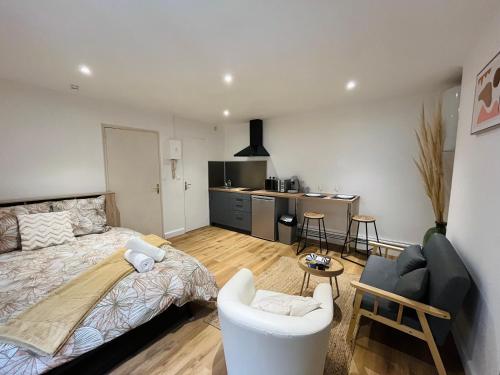 une chambre avec un lit et un salon dans l'établissement La ruche Arrageoise - Parking gratuit - Cozy - Grand lit - Long séjour, à Arras