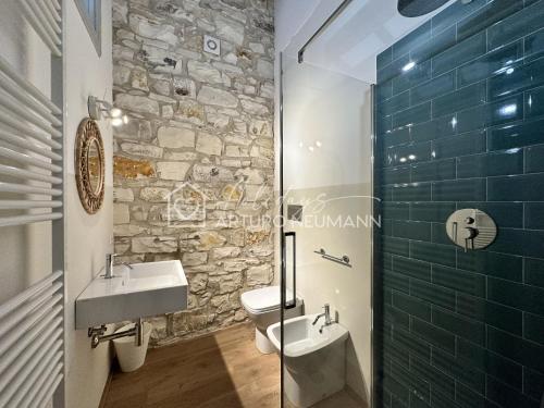 a bathroom with two sinks and a stone wall at 202 - Villa Fernanda Trilocale elegante bellissimo, con 2 bagni, in Centro a pochi passi dal mare - SPIAGGIA e NAVETTA WHITE BEACH CLUB OMAGGIO dal lun al ven dal 24-08 in Sirolo