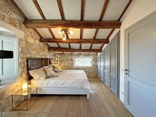 a bedroom with a bed and a stone wall at 202 - Villa Fernanda Trilocale elegante bellissimo, con 2 bagni, in Centro a pochi passi dal mare - SPIAGGIA e NAVETTA WHITE BEACH CLUB OMAGGIO dal lun al ven dal 24-08 in Sirolo