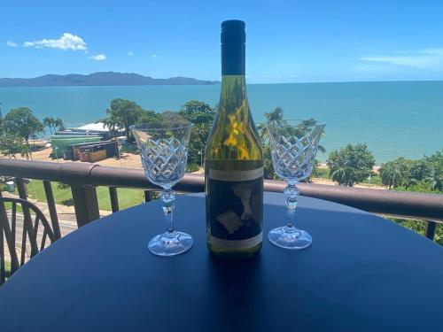 a bottle of wine sitting on a table with two glasses at It's all about the views! in Townsville