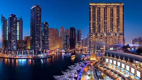 a city skyline at night with a river and buildings at Marina Mall Apartments, Dubai Marina in Dubai