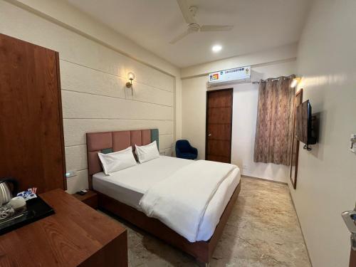Kasa Comfort Inn في إندوري: غرفة نوم بسرير ابيض كبير وتلفزيون