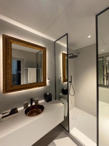a bathroom with a sink and a mirror at Hotel Palazzo Durazzo Suites in Genova