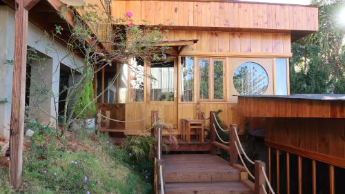 a house with a wooden staircase leading to a porch at Chiburo Home Đà Lạt in Da Lat