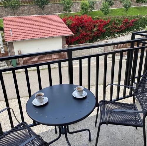 a blue table with two cups and chairs on a balcony at Apartmani Vila Ana in Gunjica