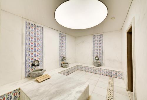 um grande quarto com um grande lustre e azulejos nas paredes em Ladonia Hotels Mio Bianco em Akiarlar