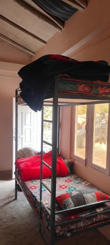 a bunk bed in a room with a window at Saanidhya hostels in Mukteswar