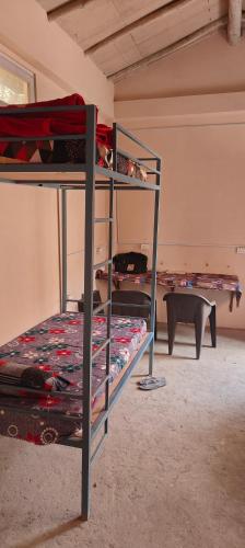 um quarto com 2 beliches e uma mesa em Saanidhya hostels em Mukteshwar