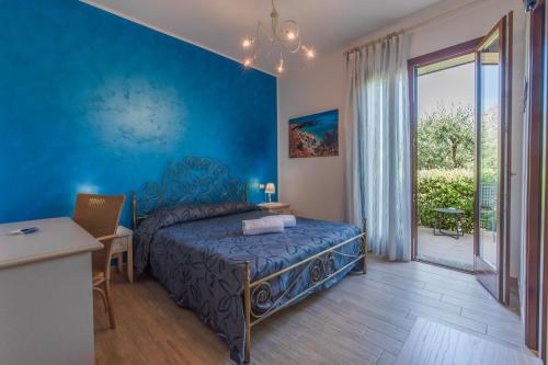a bedroom with a bed and a blue wall at I Segreti di Antonina in Castelluzzo