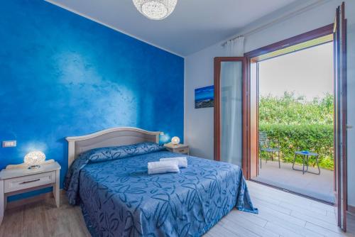 a blue bedroom with a bed and a sliding glass door at I Segreti di Antonina in Castelluzzo