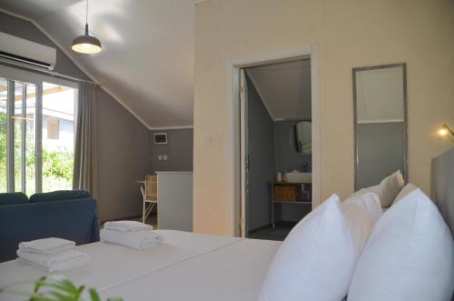 a bedroom with a white bed and a living room at Quonset Glamping in Seferihisar