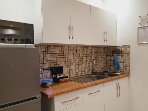 a kitchen with white cabinets and a sink at Rhino Manor in Vanderkloof