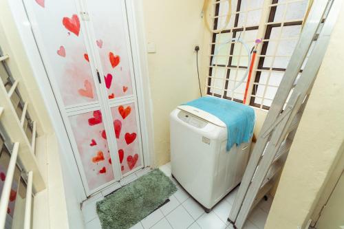 a small bathroom with a washing machine in a room at GLYSM Tambun Stay in Ipoh