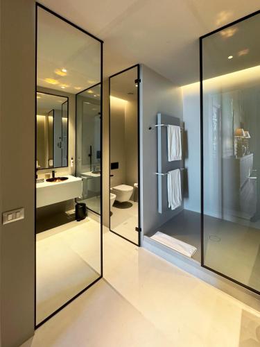 a bathroom with glass walls and a toilet and a sink at Hotel Palazzo Durazzo Suites in Genova