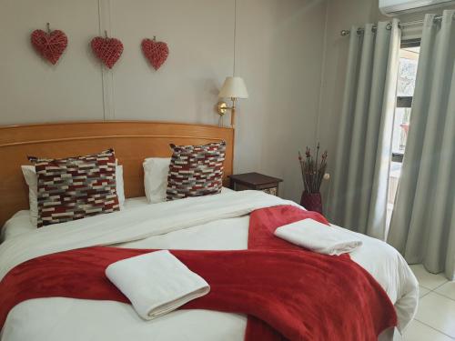 a bedroom with a large bed with hearts on the wall at Rhino Manor in Vanderkloof