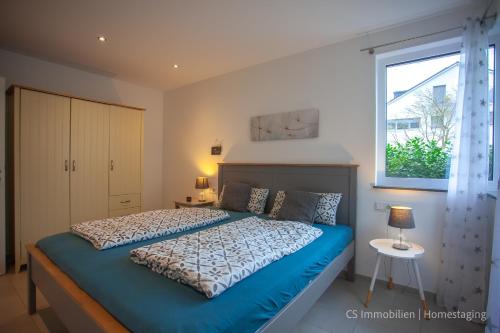 1 dormitorio con cama azul y ventana en Lago Azzurrro en Langenargen