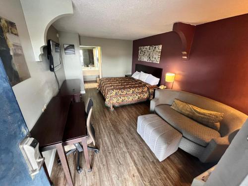 a small hotel room with a bed and a couch at Southern Inn in Manchester