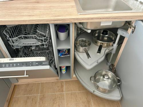 an open dishwasher under a kitchen counter with a sink at Apartmán v srdci Poděbrad 100m2 in Poděbrady