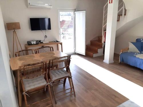 a living room with a table and chairs and a bed at River & Beach Apartment near Lisbon in Trafaria