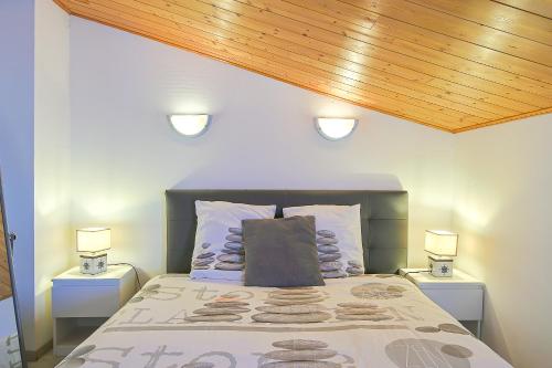 Un dormitorio con una cama con dos luces. en Maison 5pers 10min à pied plage en LʼÉpine