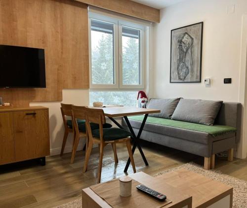 a living room with a couch and a table at Apartman Lenka Villa Mont Jahorina in Jahorina
