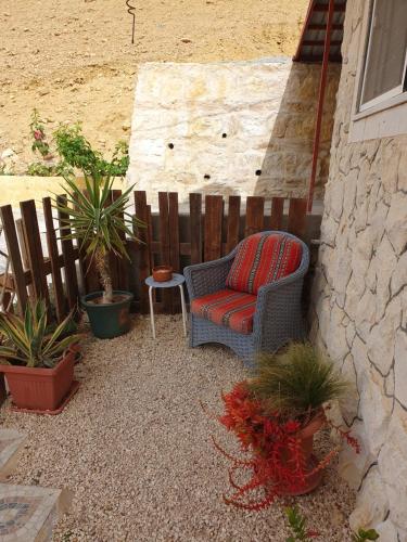 a chair sitting next to a fence with plants at The Little B&B on the Hill in Wadi Musa