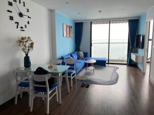 ein Wohnzimmer mit einem Tisch und einem blauen Sofa in der Unterkunft Ha Long Bay View Apartment in Hạ Long