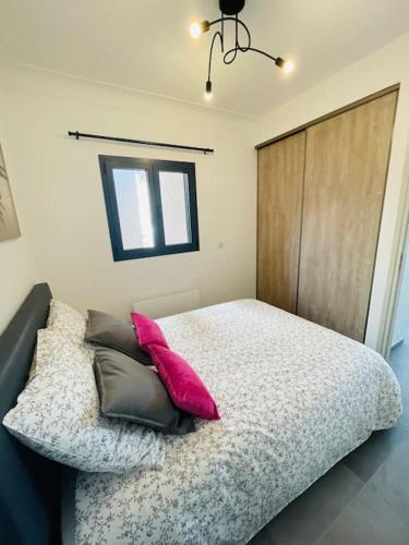 une chambre avec un lit avec des oreillers dessus dans l'établissement Cocon 4 pers vue mer, à Menton
