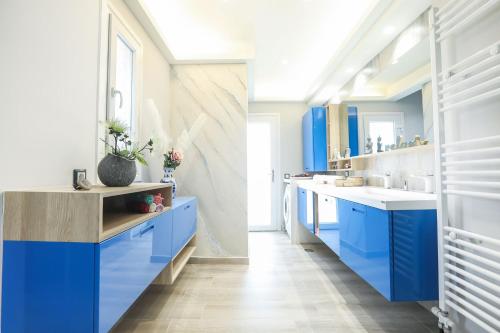 La salle de bains est pourvue de placards bleus et d'un lavabo. dans l'établissement Ulivi Verdi Villa, à Kontokali
