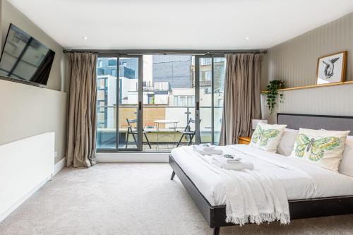 a bedroom with a large bed and a balcony at Fantastic Multilevel 3BR, Vibrant Angel, 5min Tube in London