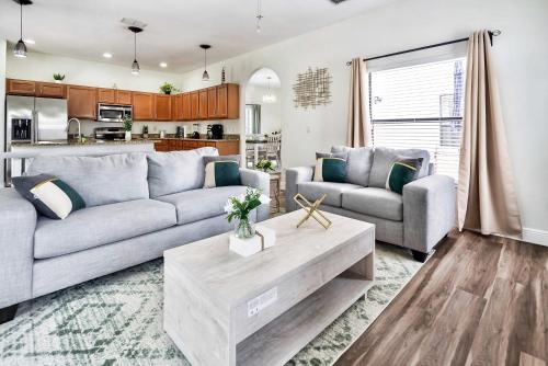 a living room with a couch and a table at Spacious 4BR Home Perfect for Families in Orlando